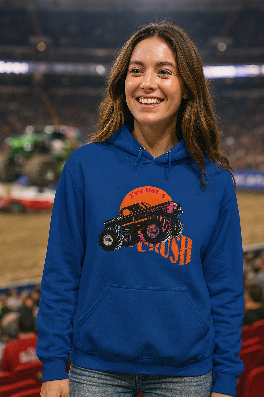 Woman wearing a blue bonspeed Monster Truck hoodie with a graphic design of a car and text, standing in an indoor arena.