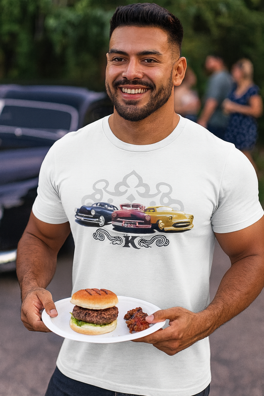 Man holding a plate with a burger and fries, wearing a white bonspeed Kustom car t-shirt with car graphics.