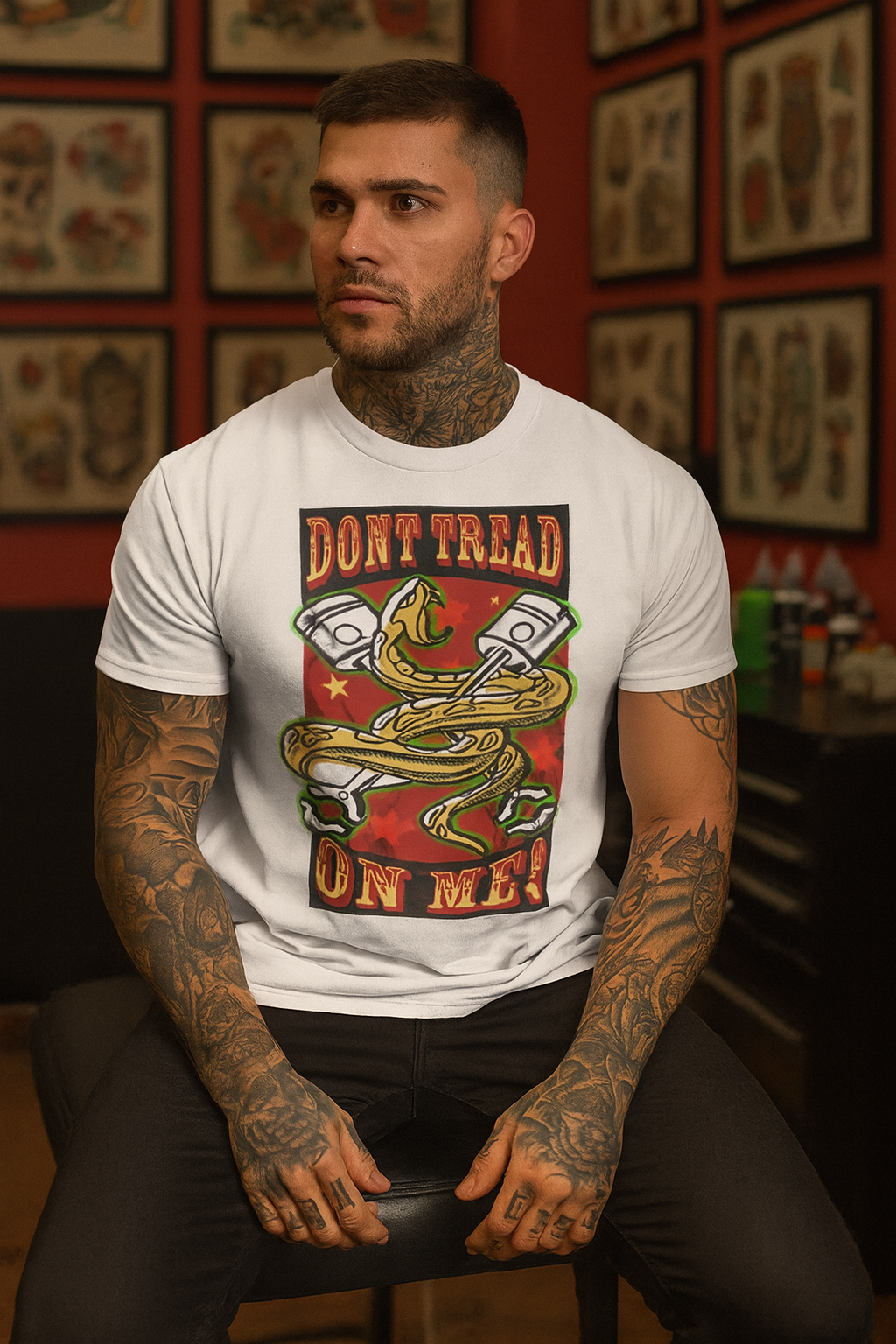 Man wearing a white bonspeed
 t-shirt with a graphic design in a tattoo parlor.