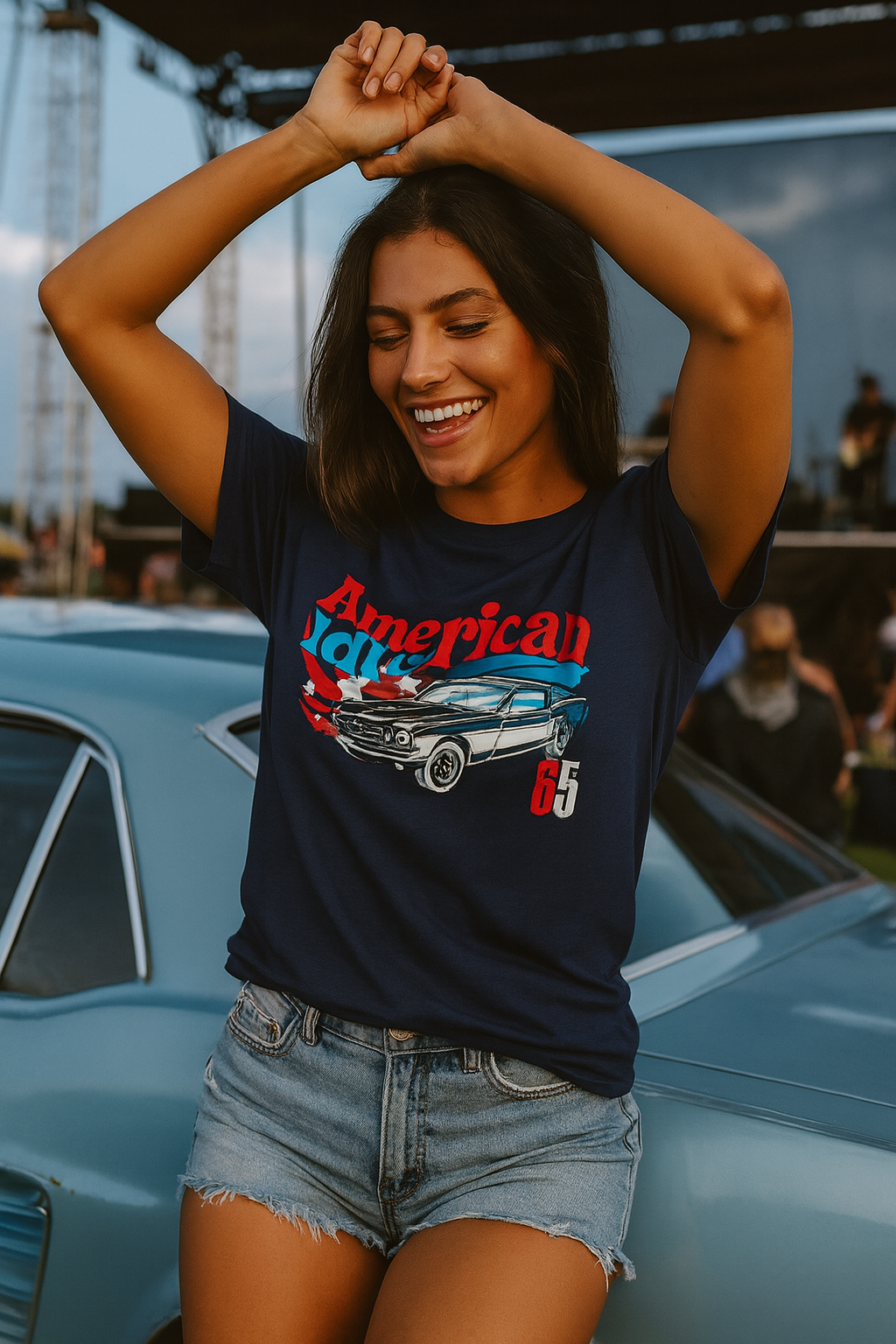 Woman wearing an 'American Idol' t-shirt with a car graphic, standing next to a classic car.
