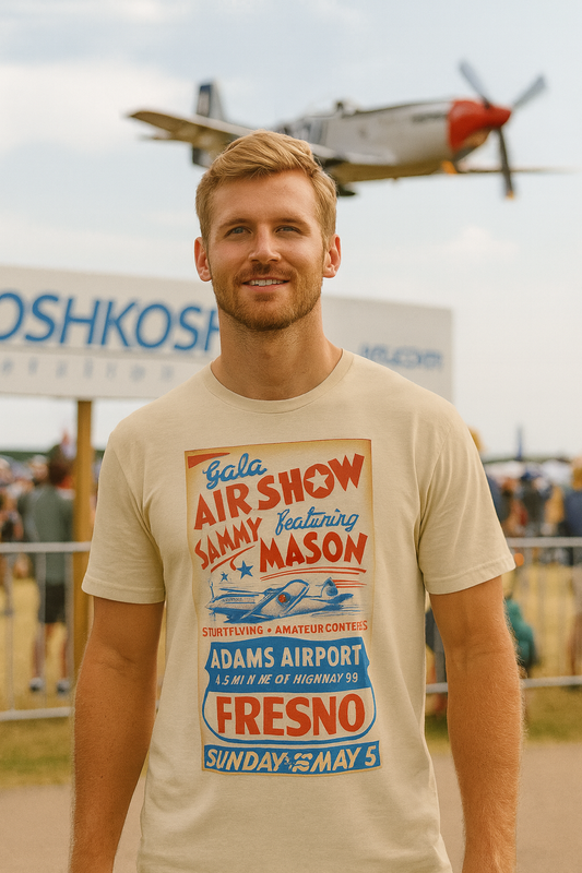 Man wearing a vintage-style P51  t-shirt with air show text, standing in front of an airplane at an airshow.